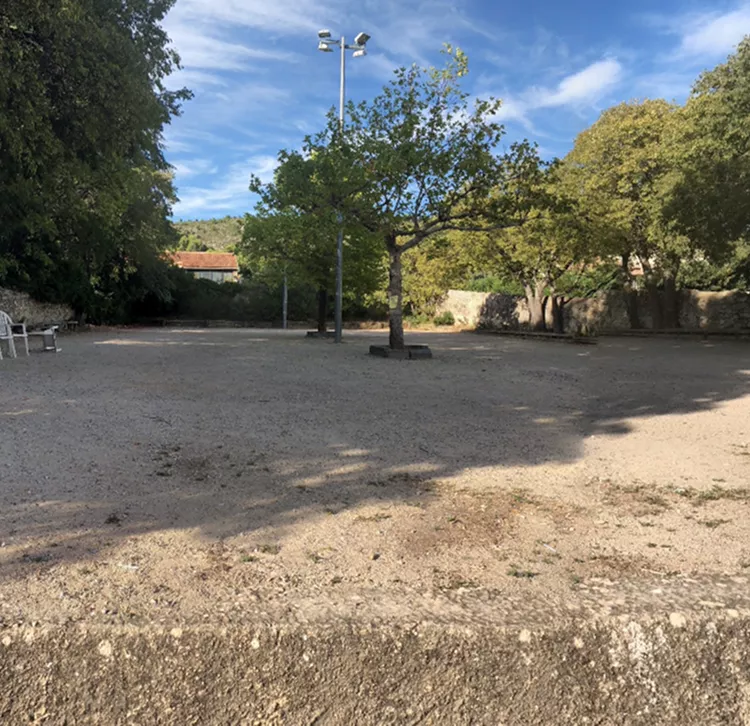 Vue du boulodrome de Mérindol, espace convivial et ouvert au cœur du village où se déroulent des parties de pétanque et des rencontres intergénérationnelles