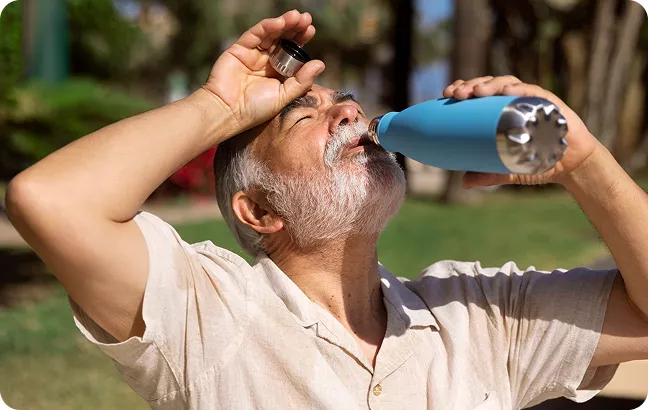 Homme buvant à sa gourde sous le soleil, illustrant le registre nominatif pour le suivi des personnes vulnérables en cas de canicule ou d’alerte sanitaire à Mérindol. Inscription volontaire et confidentielle pour les seniors via le CCAS ou la mairie. 