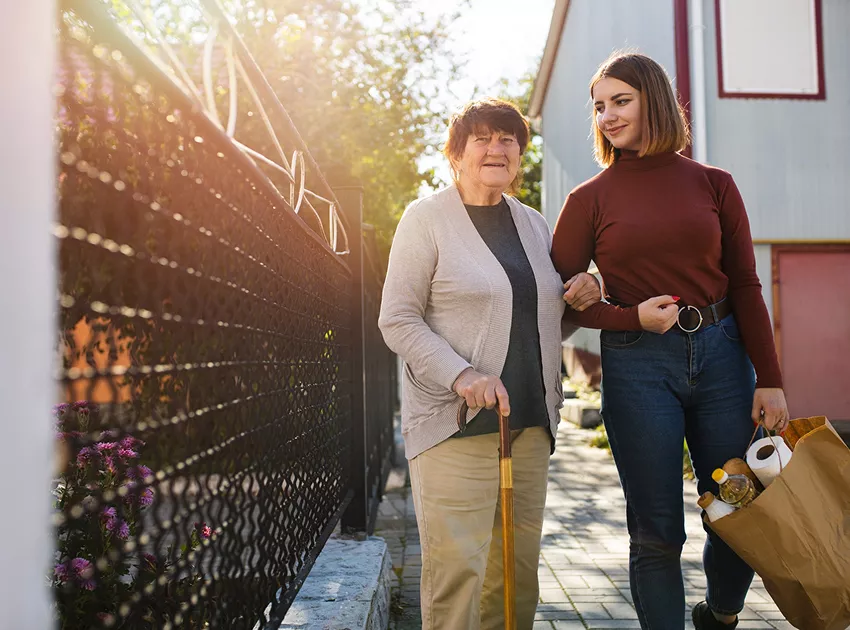 Jeune aide à domicile accompagnant une personne âgée pour faire ses courses, illustrant le service d’accompagnement quotidien proposé aux habitants en perte d’autonomie à Mérindol.
