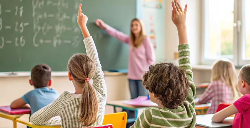 Salle de classe de l’école de Mérindol où des ateliers favorisent l’autonomie des élèves, avec une enseignante accompagnant un groupe d’enfants, dans un cadre propice aux projets pédagogiques et à la différenciation 