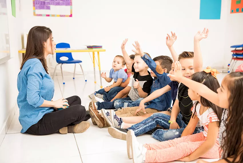  Enseignante encadrant de jeunes élèves dans une salle de classe, illustrant le cadre éducatif et rassurant de l’accueil périscolaire à Mérindol.